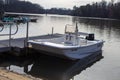 A white fishing boat attached in the dock at a park