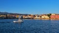 White fishing boat passing by Old Venetian harbour quay and Maritime museum in Chania, Crete, Greece. Cretan hills and Royalty Free Stock Photo