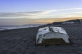 White fishing boat at sunrise on sandy beach, Tropical Seascape with a wooden, old and broken white boat on white beach on warm su Royalty Free Stock Photo