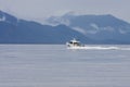 White Fishing Boat Toward Blue Mountains
