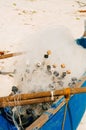 White fishing nets in the blue boat on the beach Royalty Free Stock Photo