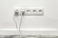 White five-way wall power socket on white wall