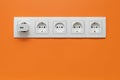 White five-way wall power socket on white wall