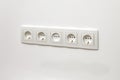 White five-way wall power socket on white wall