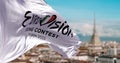 The white flag with the Eurovision Song Contest 2022 logo waving in the wind with blurred landscape of Turin