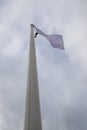 White flag on the mast near the beach. Flag on a background of cloudy sky Royalty Free Stock Photo