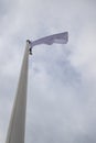 White flag on the mast near the beach. Flag on a background of cloudy sky Royalty Free Stock Photo