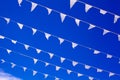 White flags waving on wind, blue sky background close up, banners flap on breeze, decorative garlands floats in air, beautiful