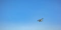 White float plane flying beneath blue sky