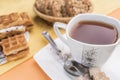 White with a floral pattern mug with tea, a spoon and lump brown sugar lie on a white square saucer Royalty Free Stock Photo