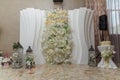 White floral wedding presidium for just married, geometric arch with white flowers and lanterns