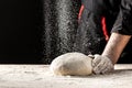 White flour flying into air as pastry chef in white suit slams ball dough on white powder covered table. concept of nature, Italy Royalty Free Stock Photo