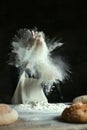 White flour on rustic wooden table. Cook slams splash hands with flour. White dust cloud of flour