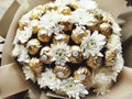 A white flower bouquete with ferrero rocher chocolate.