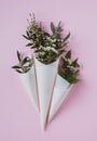 White flowers in paus tracing paper cone on pink background