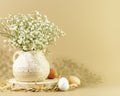 White flowers in vase and eggs on wooden podium