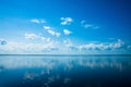 White fluffy clouds blue sky above a surface of the sea Royalty Free Stock Photo