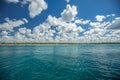 White fluffy clouds blue sky above a surface of the sea Royalty Free Stock Photo