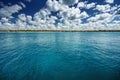 White fluffy clouds blue sky above a surface of the sea Royalty Free Stock Photo