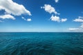 White fluffy clouds blue sky above a surface of the sea Royalty Free Stock Photo