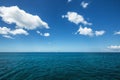 White fluffy clouds blue sky above a surface of the sea Royalty Free Stock Photo