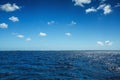 White fluffy clouds blue sky above a surface of the sea Royalty Free Stock Photo