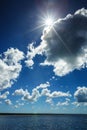 White fluffy clouds blue sky above a surface of the sea Royalty Free Stock Photo