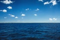 White fluffy clouds blue sky above a surface of the sea Royalty Free Stock Photo