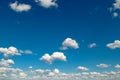 White fluffy clouds and sun on dark blue sky Royalty Free Stock Photo