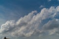 White fluffy clouds rise from left to right across the blue sky, abstractly hinting at the right direction for growth