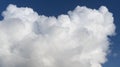 White fluffy cumulus cloud on a bright blue sky in sunny weather Royalty Free Stock Photo