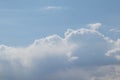 White fluffy large cumulus clouds in the vastness of a light blue sky under the rays of a bright sun in the morning Royalty Free Stock Photo