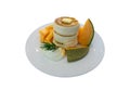 White fluffy pancake and butter topping on white ceramic plate decorated with yellow and green melon and smooth wipping cream