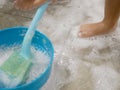 White foam and air bubbles at baby`s feet on the bathroom floor, as she is haveing fun learning to clean a restroom Royalty Free Stock Photo