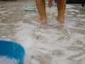 White foam and air bubbles at baby`s feet on the bathroom floor, as she is haveing fun learning to clean a restroom Royalty Free Stock Photo