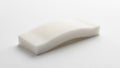 White foam cleaning sponge with a curved shape placed on a white surface Royalty Free Stock Photo