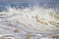 White foam and water droplets forming at the top of a wave as it breaks