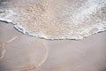 White Foamy Wave on the Dark Sand Beach Shore Royalty Free Stock Photo