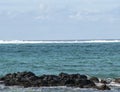 White foamy wave in distance coming in from aqua sea