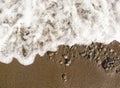 White foamy wave over sand beach. Clean tide during the day. Tropical beach top view photo. Royalty Free Stock Photo