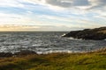 White, foamy waves crashing against coastal rocks at sunset on San Juan Island, WA Royalty Free Stock Photo