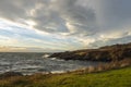 White, foamy waves crashing against coastal rocks at sunset on San Juan Island, WA Royalty Free Stock Photo