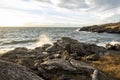 White, foamy waves crashing against coastal rocks at sunset on San Juan Island, WA Royalty Free Stock Photo