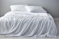 White folded duvet on white bed winter season preparation and importance of home textiles