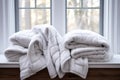 White folded duvet plaids lying on window sill at home. Preparing for winter season, household, cold winter at home