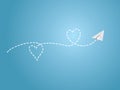 A white folded paper plane making love sign route on blue background to show happy travel emotion