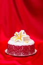 White fondant cake decorated with red lace and edible candy lily