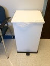 White foot operated trash can medical exam room