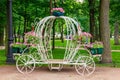 White forged decorative coach with flowers in park