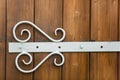 White forged hinge put on wooden door close-up Royalty Free Stock Photo